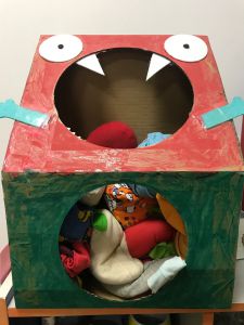 《怪物的大嘴巴》玩法：幼儿通过投掷将沙包丢进“怪物”的大嘴中则获胜。
